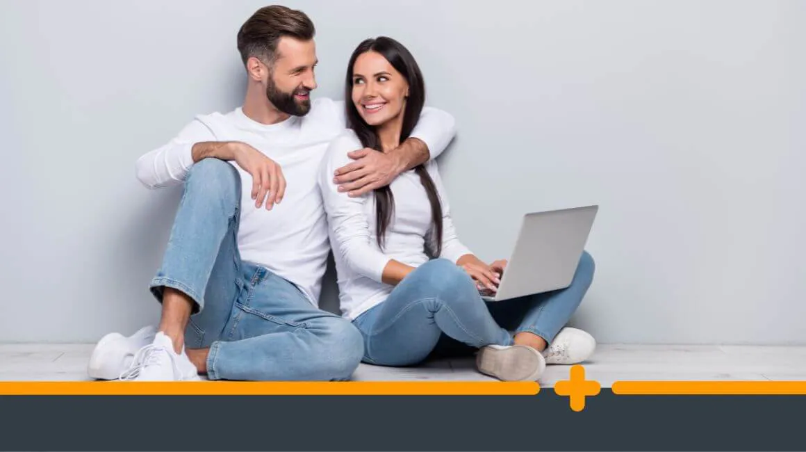 Zadowolone młodzi ludzie w białych koszulkach korzystający z laptopa